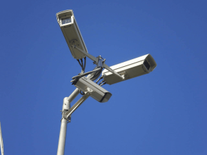Three surveillance cameras on a pole.
